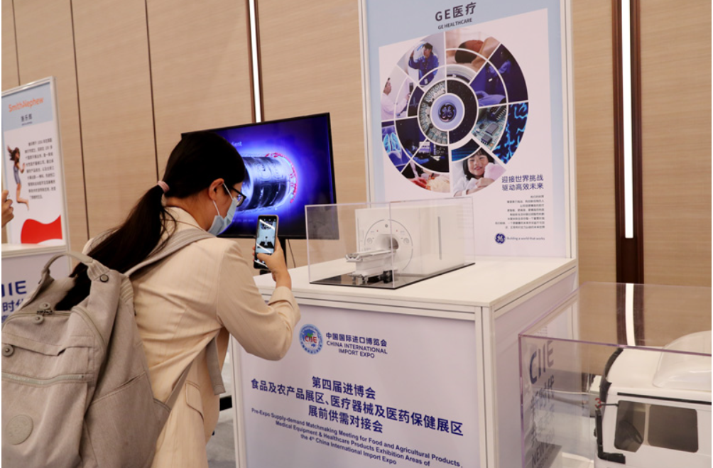 第四屆進(jìn)博會食品及農(nóng)產(chǎn)品展區(qū)、醫(yī)療器械及醫(yī)藥保健展區(qū)展前供需對接會的參會嘉賓用手機(jī)拍攝參展企業(yè)的展品模型